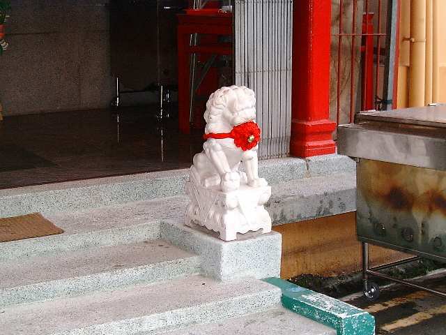 Chinese temple: white lion with a red ribbon